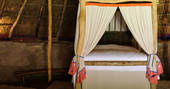 The huge comfy four poster bed inside The Roundhouse in Cornwall