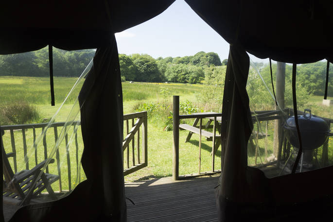 View through Welcombe safari tent at Berridon Farm. Relax on the outdoor seating and enjoy the beautiful views