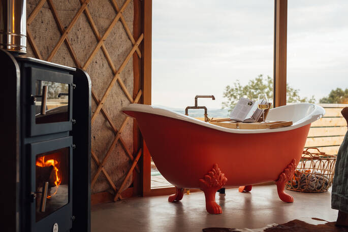 Free standing bath tub in the yurts next to the wood burner