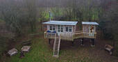 The treehouse is build amongst the trees and has a firepit area next to it