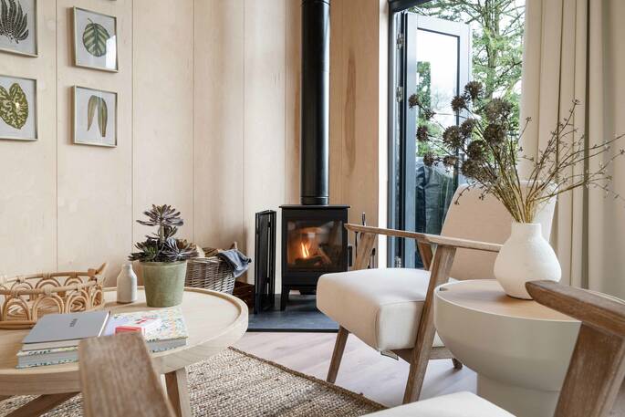 Living area with a wood burner, armchairs and a coffee table