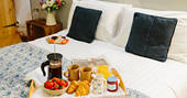 A delicious breakfast is served on the comfortable kingsize bed at The Cribbau, Penhein Glamping