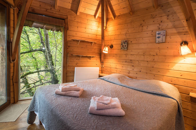 Cosy double bed at Gauthie Lakeside Treehouse, Dordogne, France