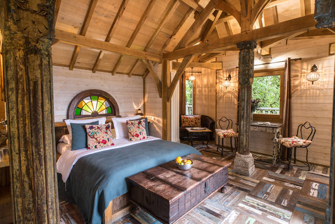 Inside Monbazillac Treehouse, double bed and seating area, Châteaux dans les Arbres, Dordogne, France
