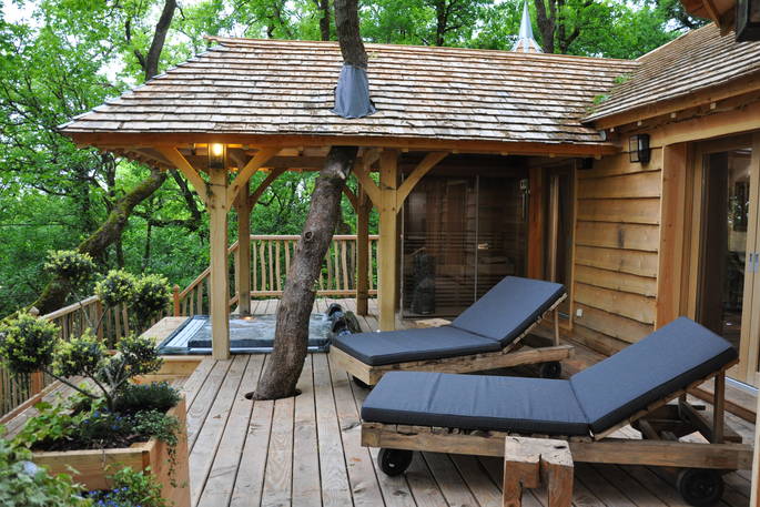 Puybeton treehouse dordogne france europe european glamping holidays exterior leafy trees balcony lounge chairs relaxing