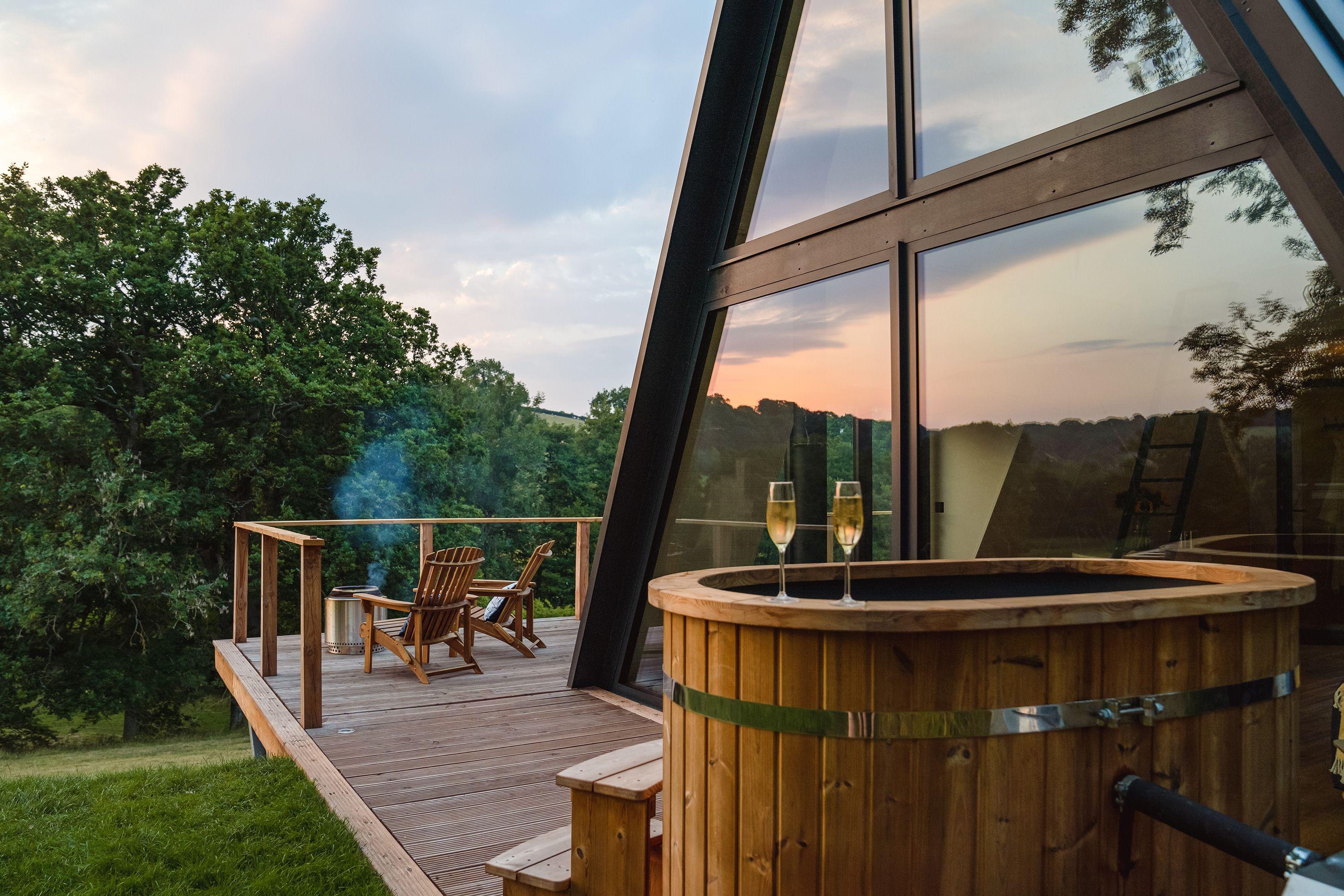 Hot tub with glasses on a decking overlooking a woodland 