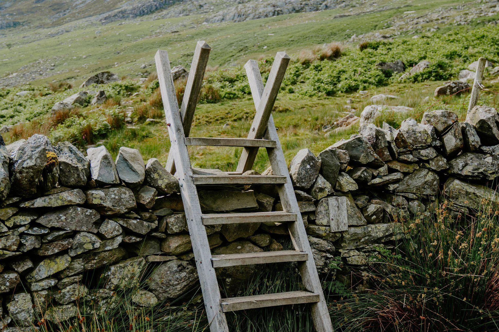 A wooden ladder over a stone wall 