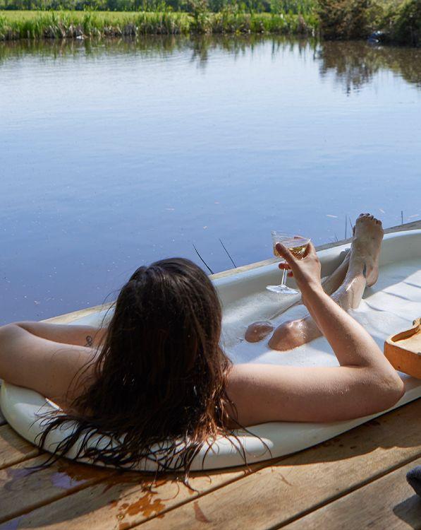 Decking bath with person holding glass of fizz