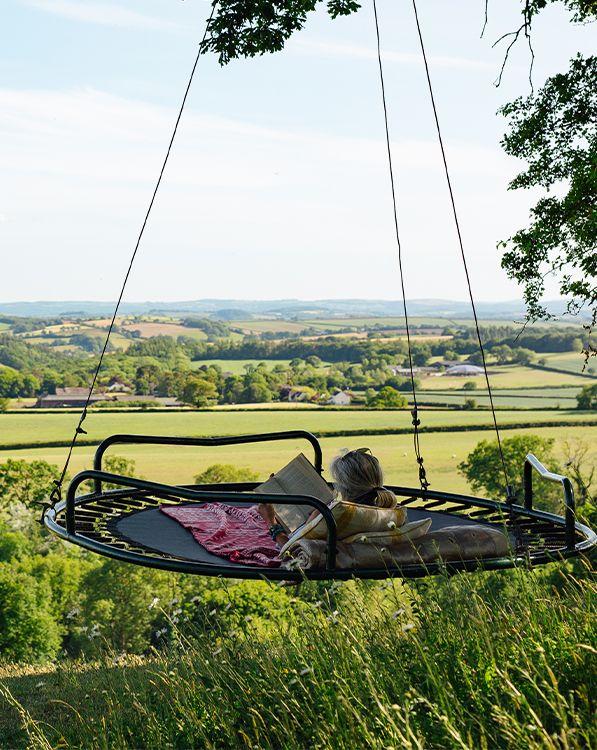 Trampoline swing with person reading and enjoying the view