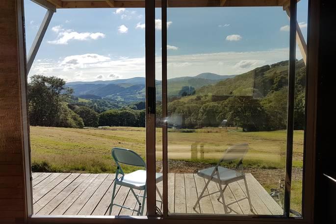 Large glass doors with outdoor seating and rural view 