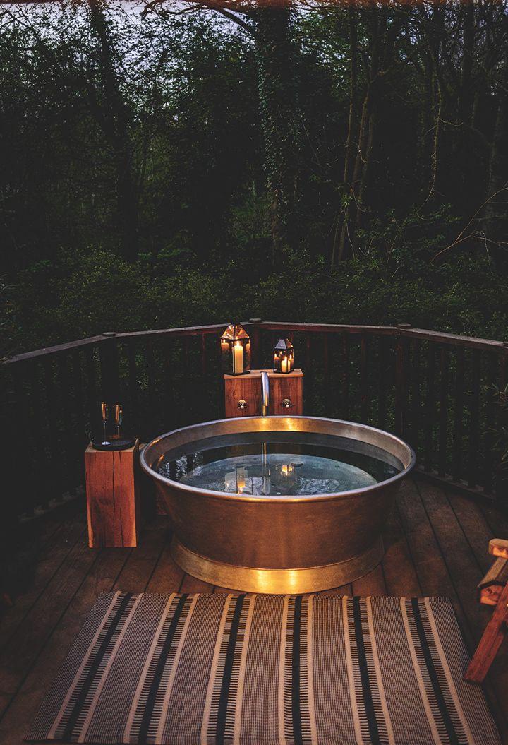 Outdoor bath on decking with woodland 