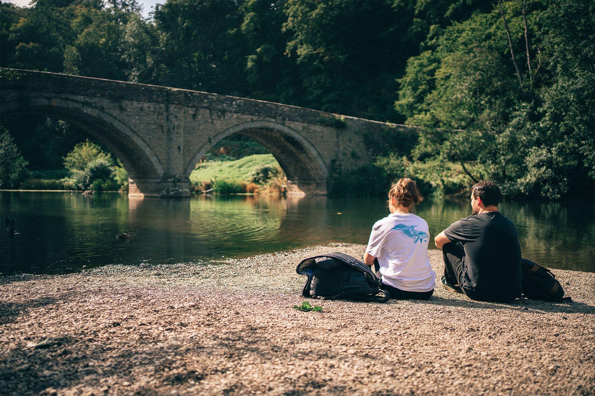 Two people relaxing on a riverbank 