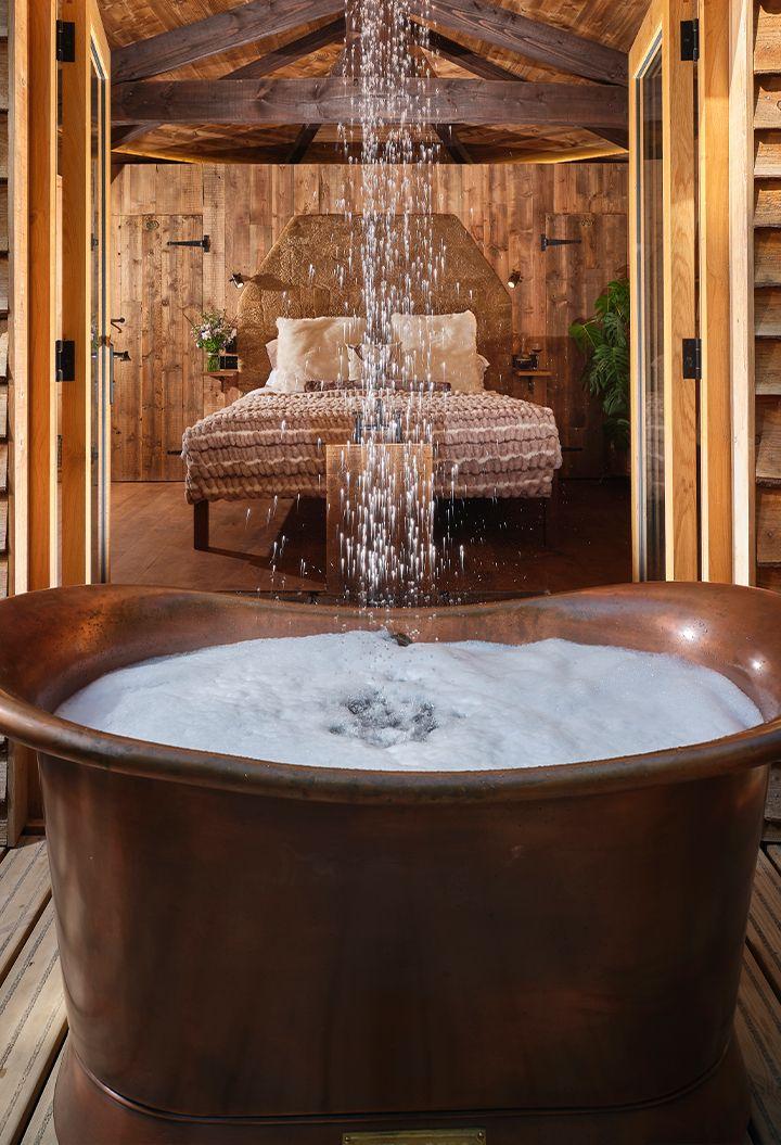 Copper bath on decking with outdoor shower