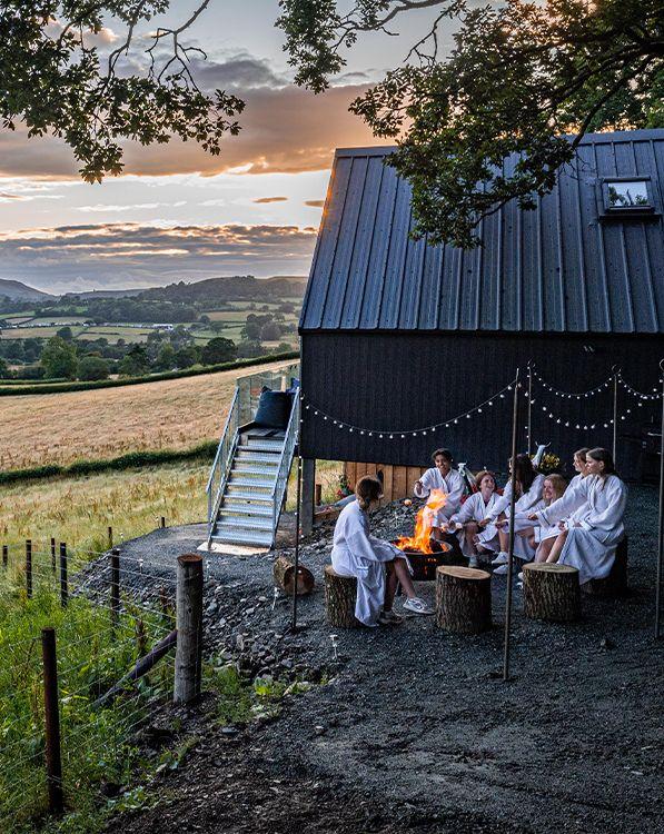 Group of people outside around campfire 