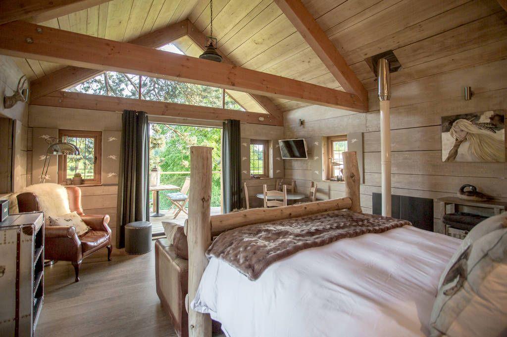Orchard Treehouse interior with bed and woodland view