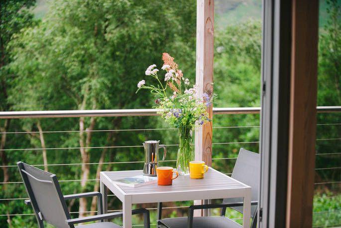 Red Squirrel Cabin balcony with wild flowers and outdoor seating 