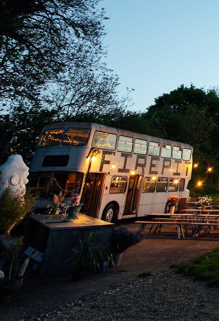 The Camping Meadow bus at night with warm lighting 