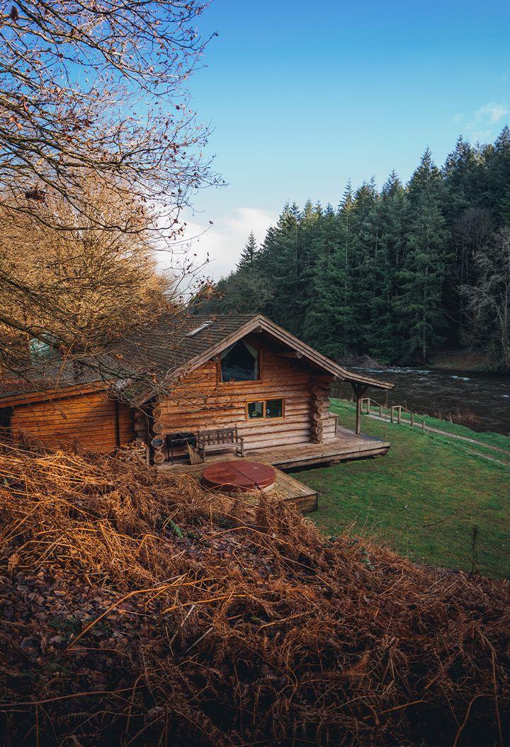 The Lodge exterior with woodland and river 