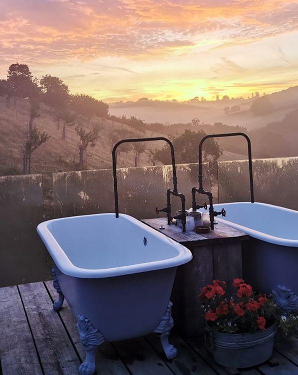 Double baths on decking with view of sunset