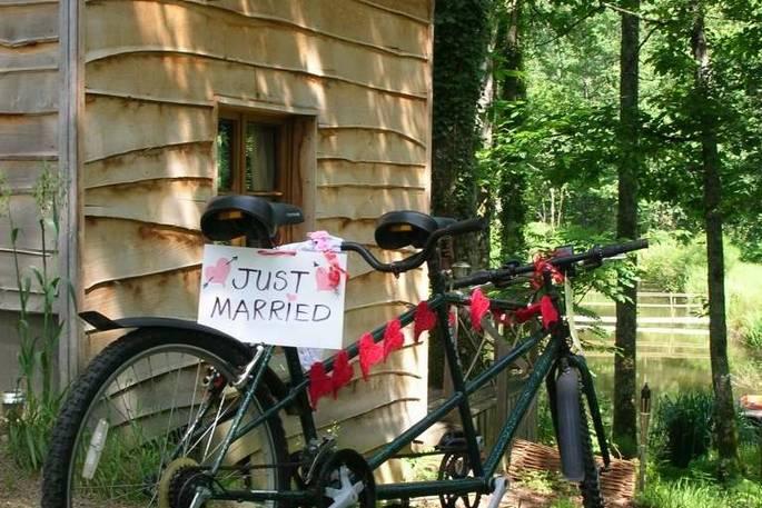 Bike with "just married" sign leaning against Woodsman's Cabin 