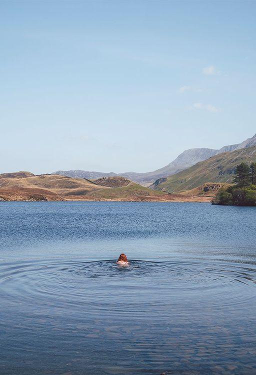 Person wild swimming in a rural area