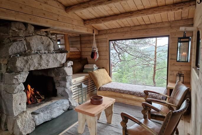 Cliff Cabin living room area with fireplace and window 