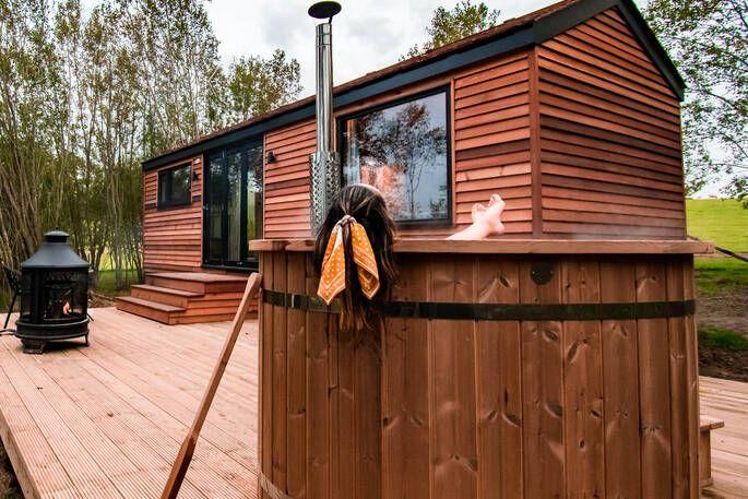 Coddiwomple Cabin person in hot tub on decking 