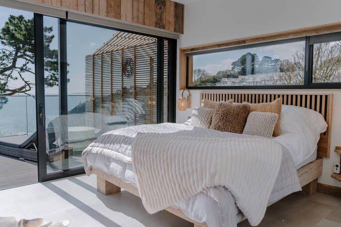 Rook's Nest bedroom with large sliding window door with view of the sea 