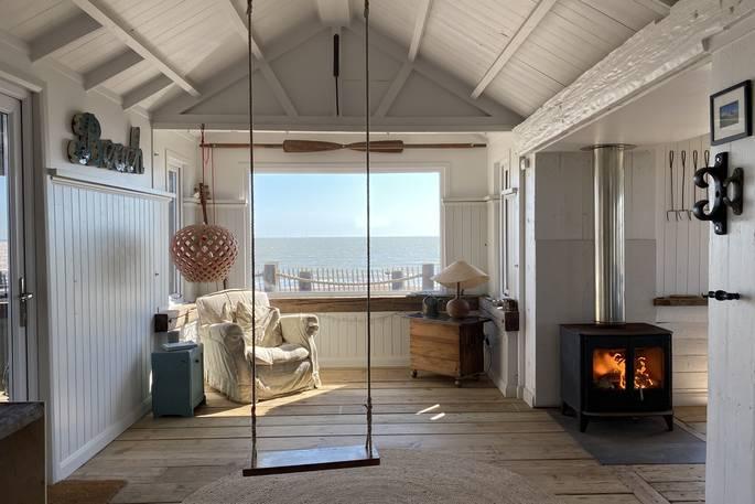The Beach House with view of the beach, indoor swing and wood burner