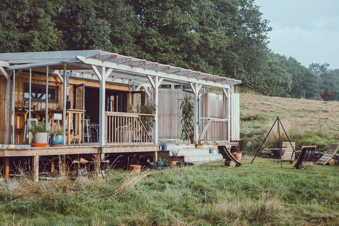 The Carn cabin in field with decking and outdoor plants 