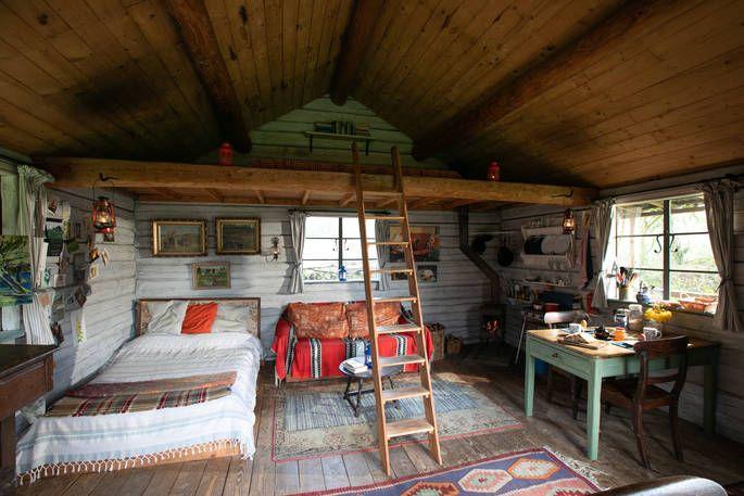 The Log House Studio interior with bed, sofa, seating area, and ladder to small second area 