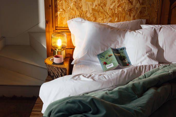 The Nook bed with warm lighting, hot drink and book