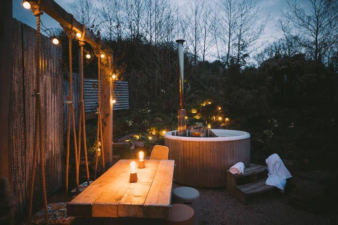 The Nook cabin's outside area with swing, out door dinning area, hot tub and fairy lights 
