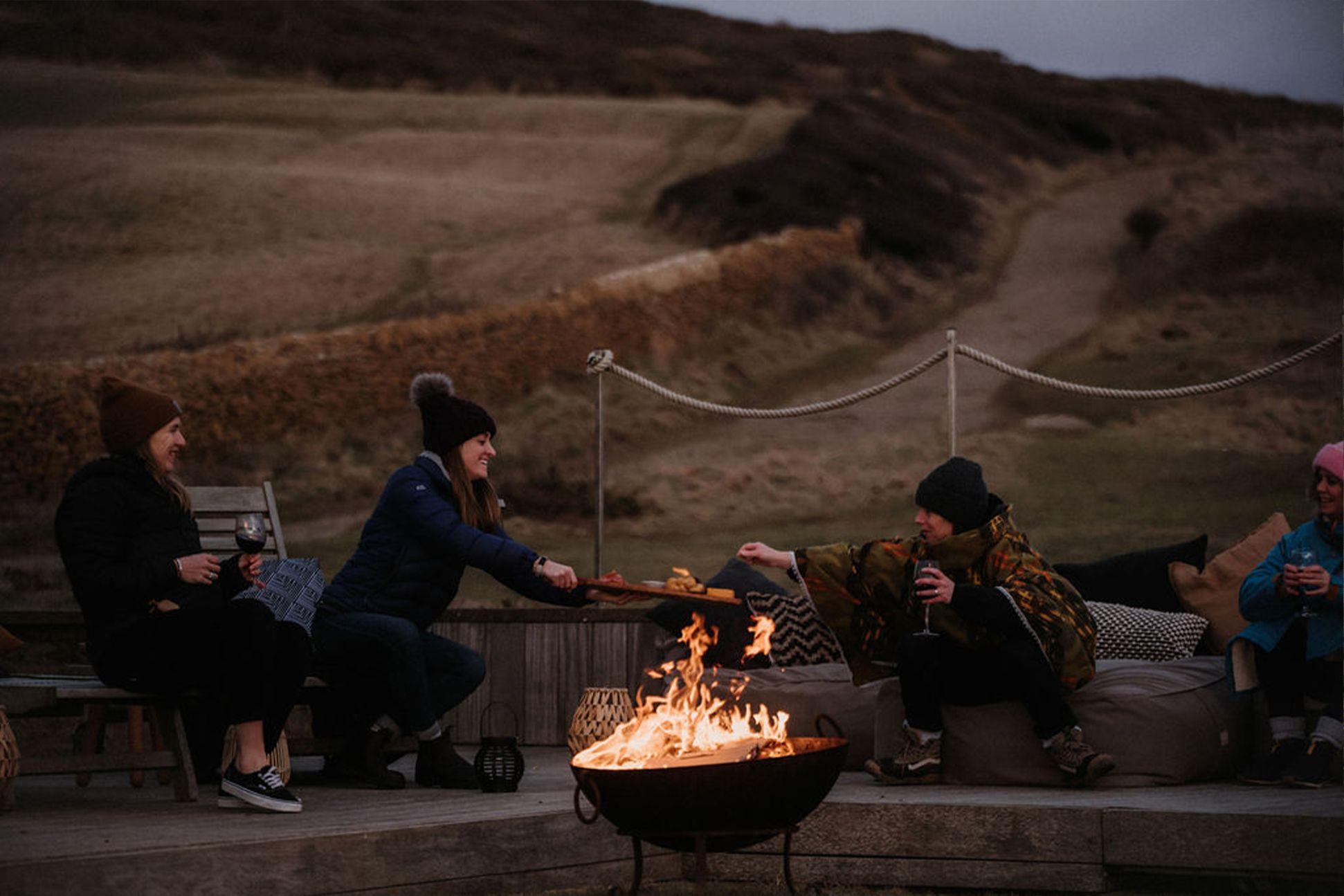 Group around a fire pit on the beach 