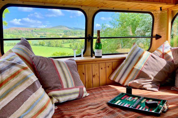 Inside glamping bus with seating and view 