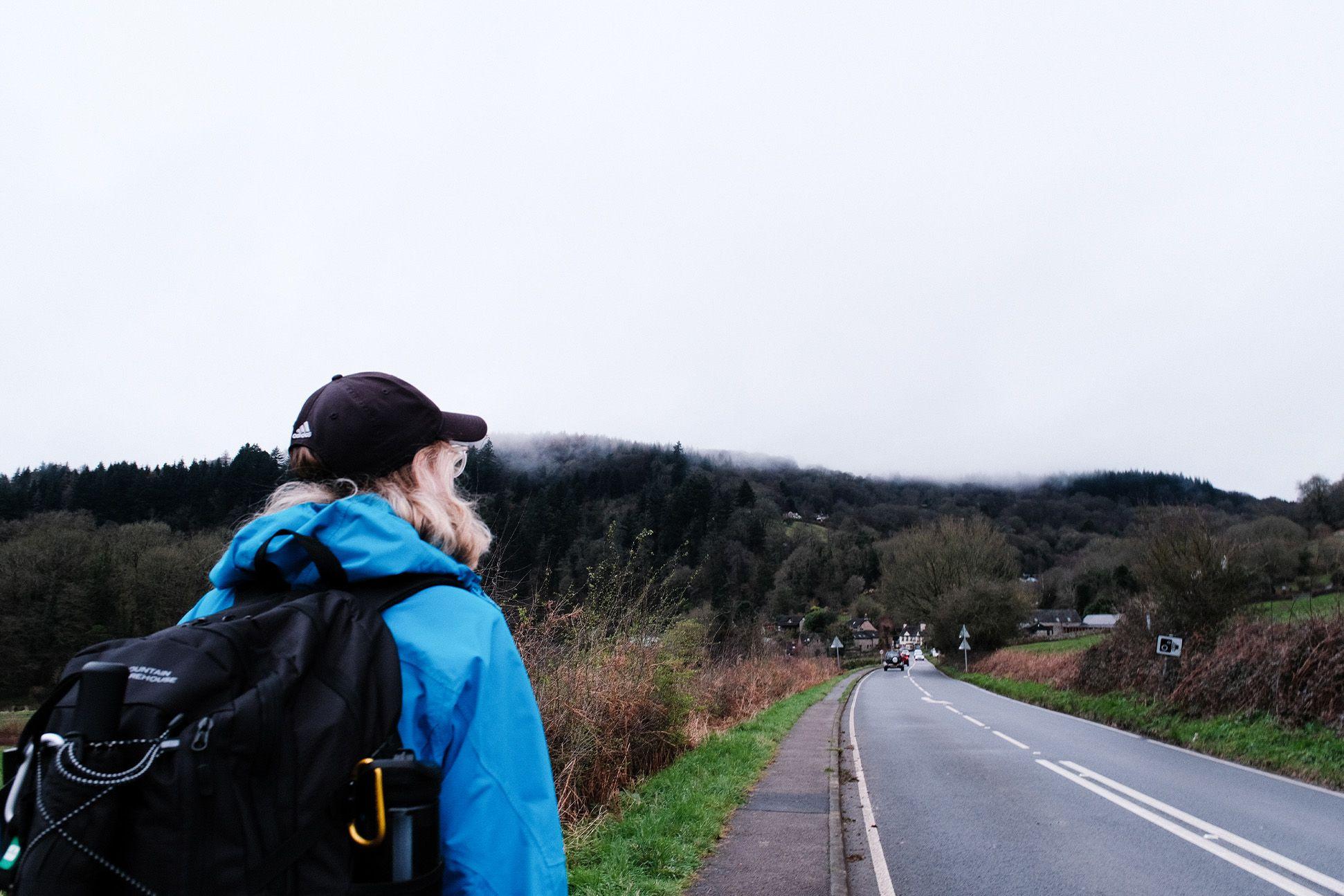 Person waiting for a bus on the roadside