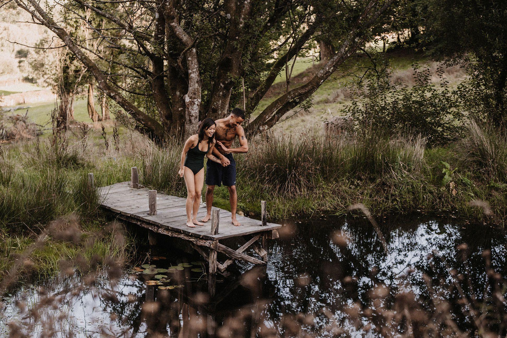 Two people diving into a wild pond 