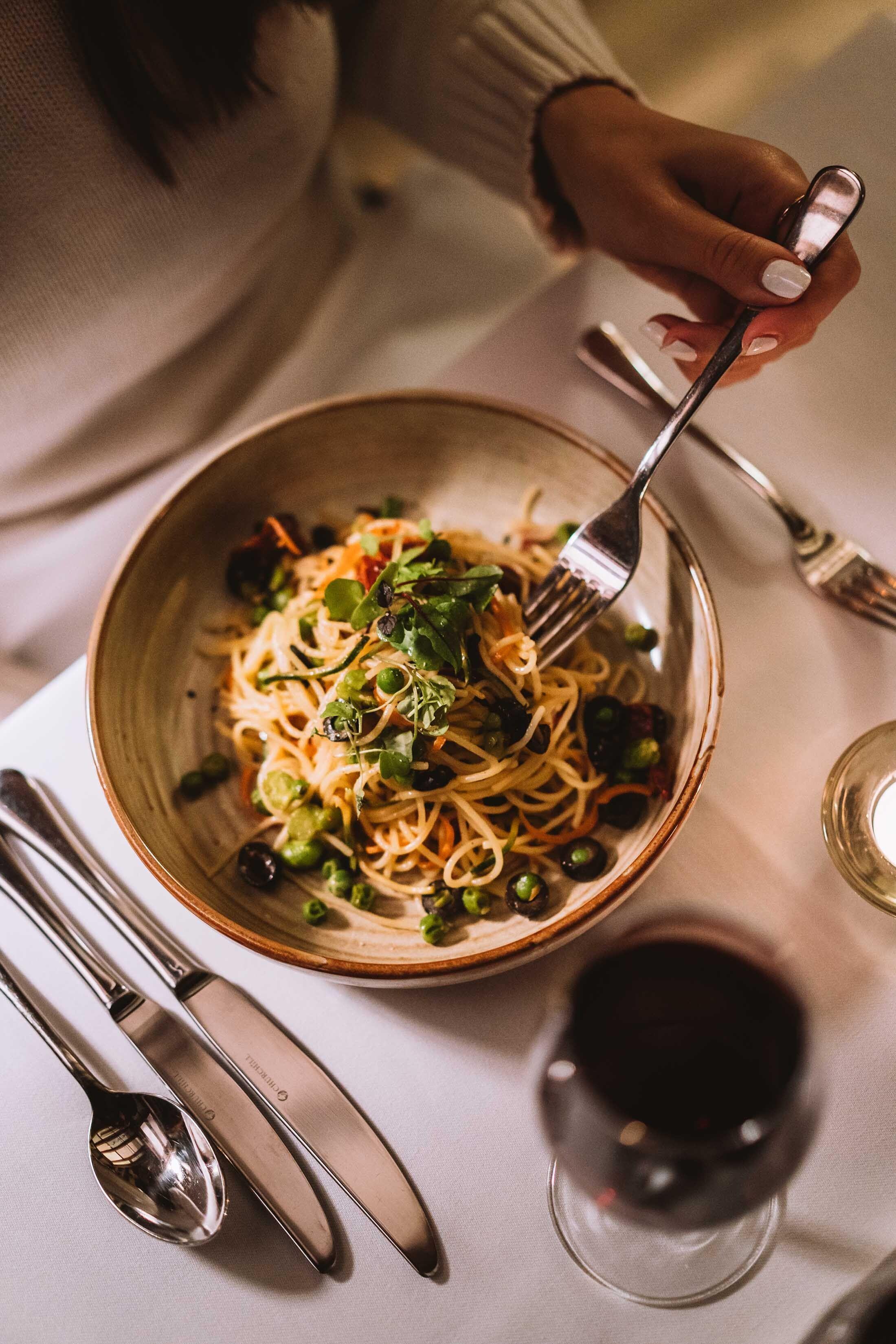 Diner eats spaghetti at table 