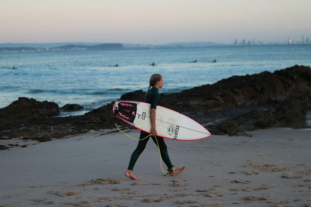 A young girl heads back to the sand after surfing