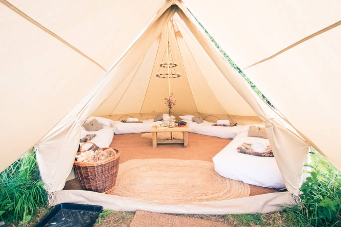 One of the four bell tents interior space with single beds and tea light chandelier 