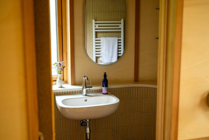 Bathroom with a hot shower, sink and flushing toilet
