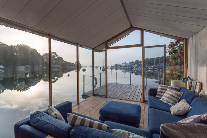 View down Penryn River towards Falmouth from the sofa of Amelie eco barge in Cormwall with the morning light on the water