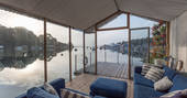 View down Penryn River towards Falmouth from the sofa of Amelie eco barge in Cormwall with the morning light on the water