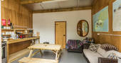 Fully equipped communal barn with stove an oven. Comfortable sofa and picnic table at Ekopod, Cornwall