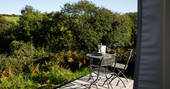 Wooden decking and seating area with bucket of champagne facing the gorgeous views of the countryside in Cornwall
