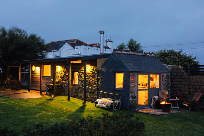 Halzephron Cabin looking warm and cosy at dusk, in Cornwall