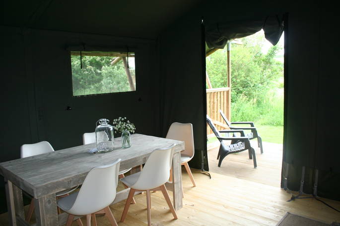 5 seated dining area leading outside of the safari tent onto the decking area at Little Nook Glamping, Cornwall