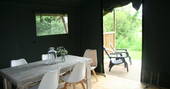 5 seated dining area leading outside of the safari tent onto the decking area at Little Nook Glamping, Cornwall