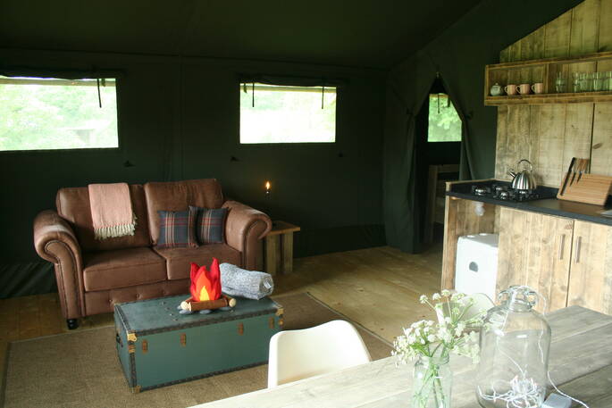 Brown leather sofa and kitchen area in Mabbs, Little Nook Glamping, Cornwall 