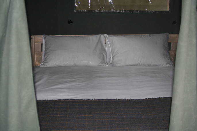 Cosy king-size bed inside of the Safari tent at Little Nook Glamping in Cornwall